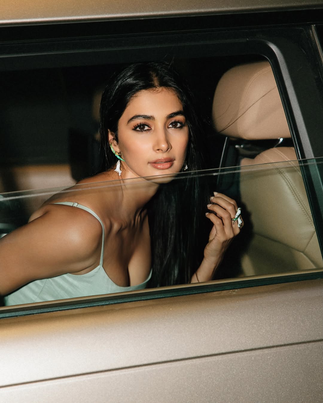 Pooja Hegde poses elegantly in a pastel-toned dress featuring sophisticated detailing and luxurious texture.