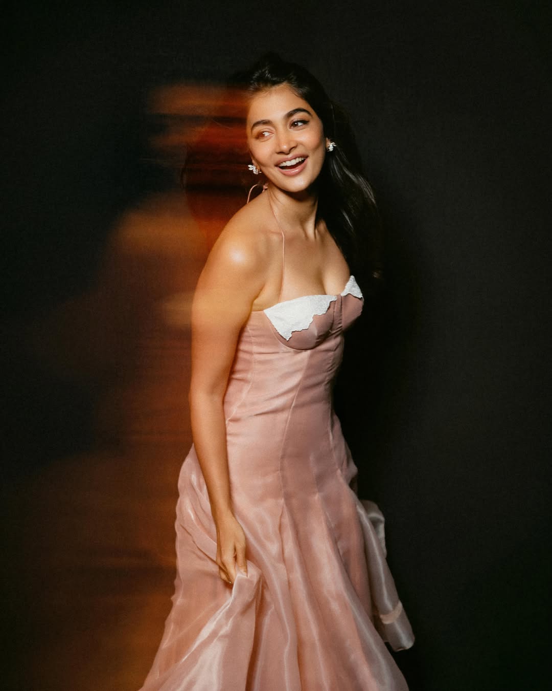 Pooja Hegde poses in an elegant gold embroidered outfit, looking radiant and poised.