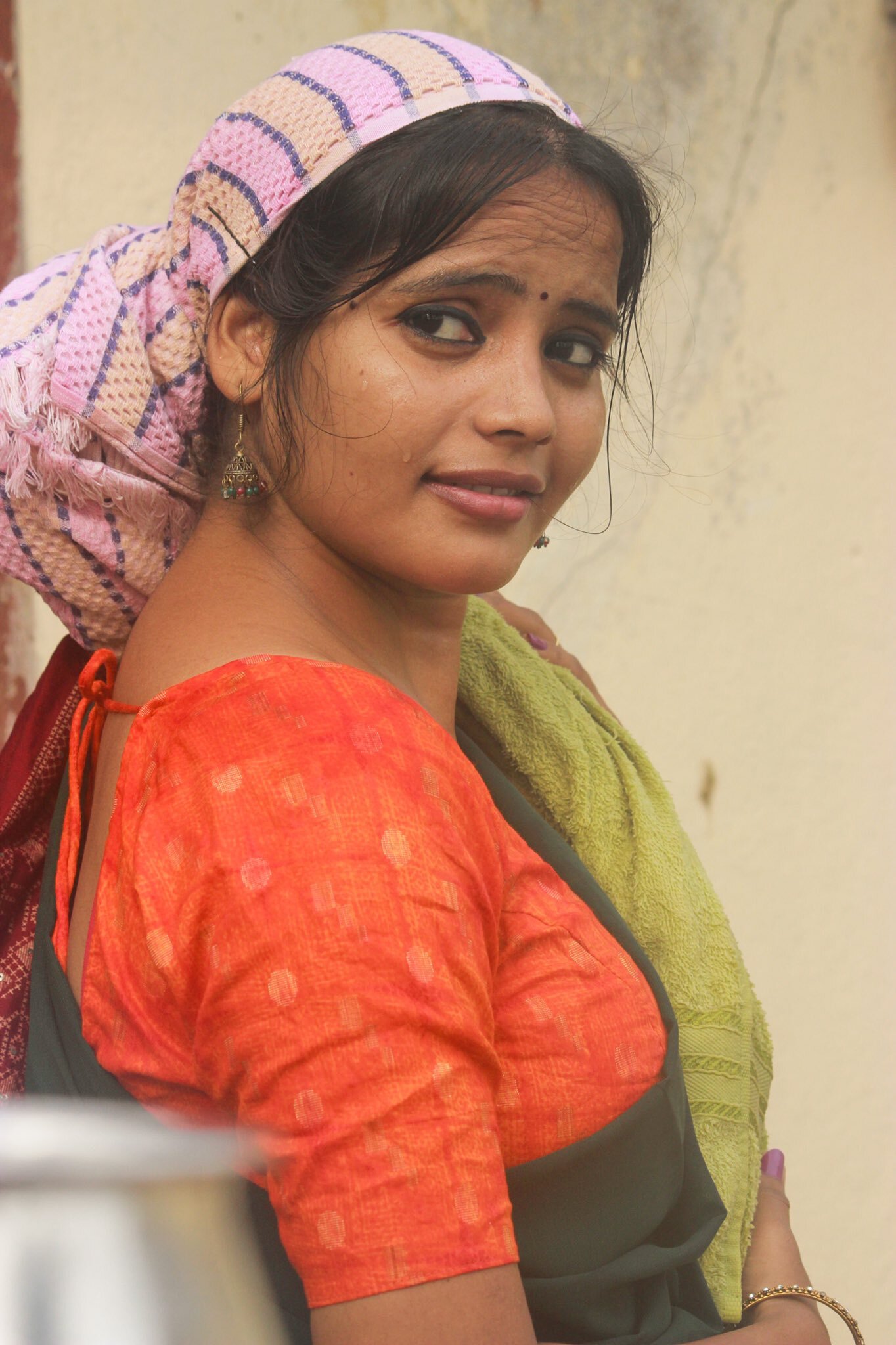 Powlenjessica Amaranathan posing elegantly in a blue and orange traditional outfit near a mirror.