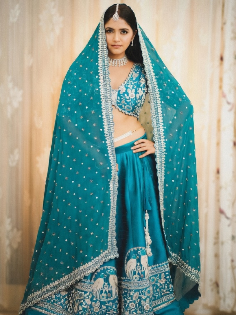 Pragya Nayan in a richly embroidered peacock blue lehenga ensemble.