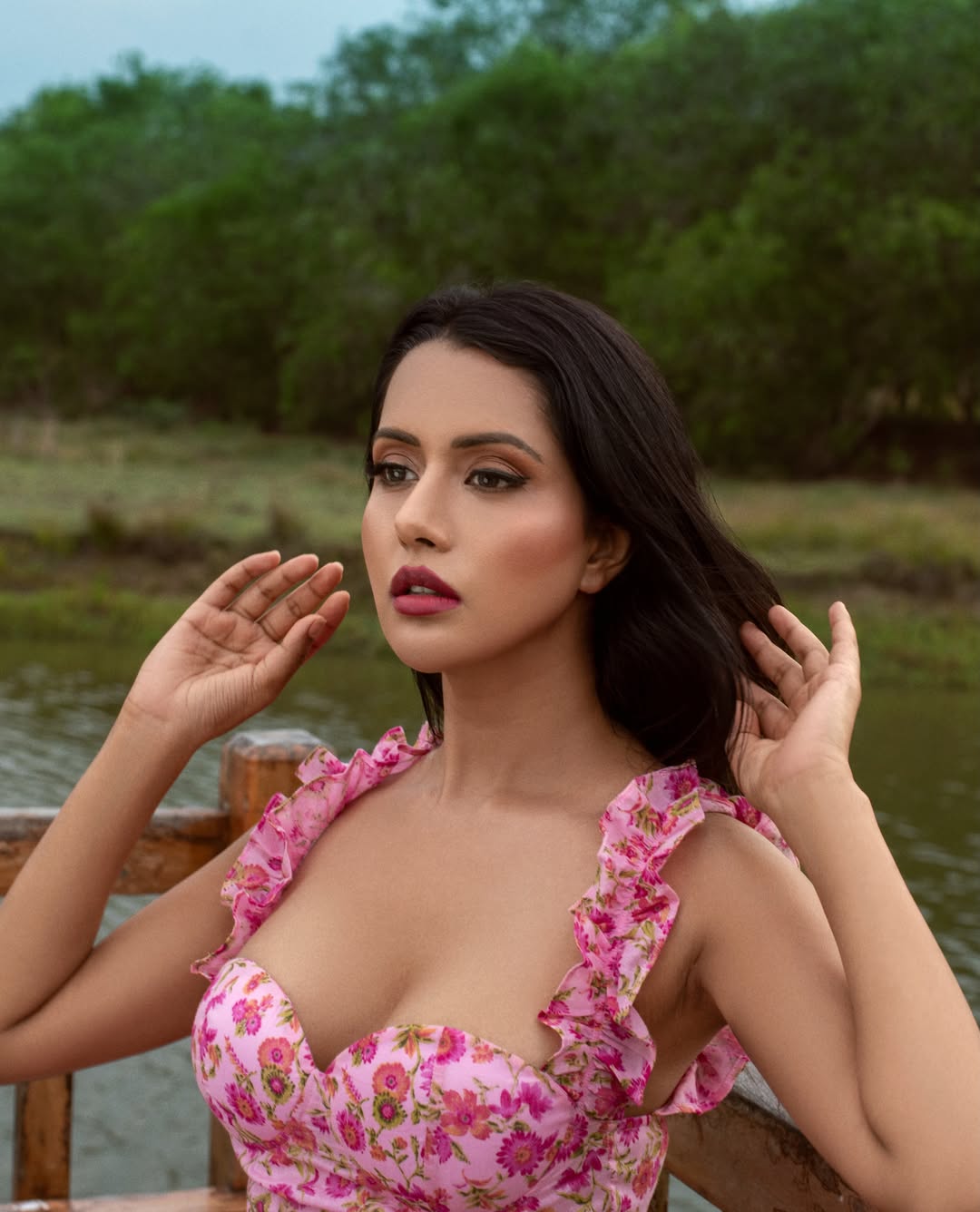 Raiza Wilson poses in a vibrant, ornate floral outfit, radiating elegance and charm.