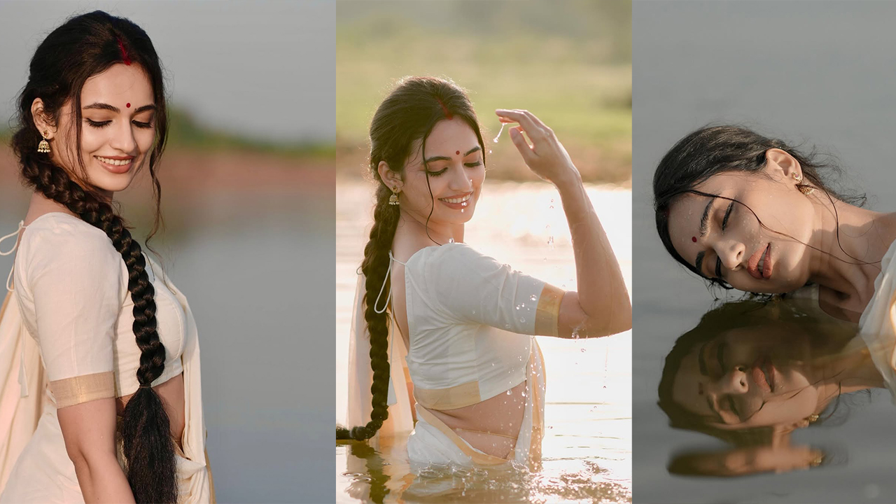 Rishika Naik standing in shallow water with a golden drape, smiling, and gold bangles.