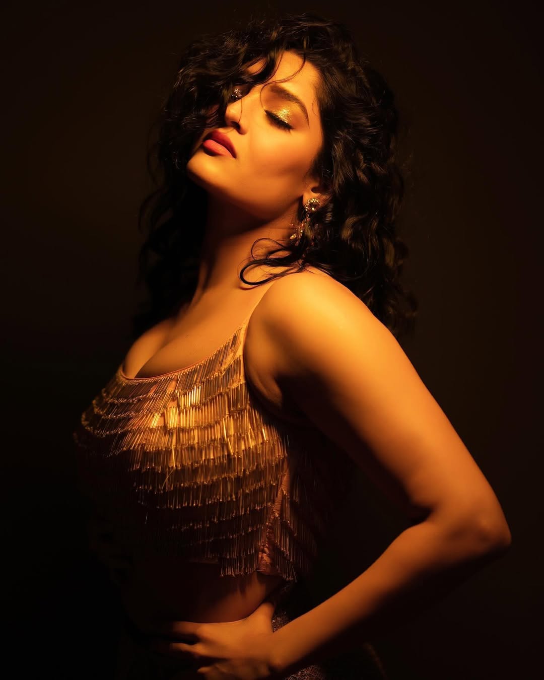 Ritika Singh posing brightly in an outdoor setting, radiating positive energy.