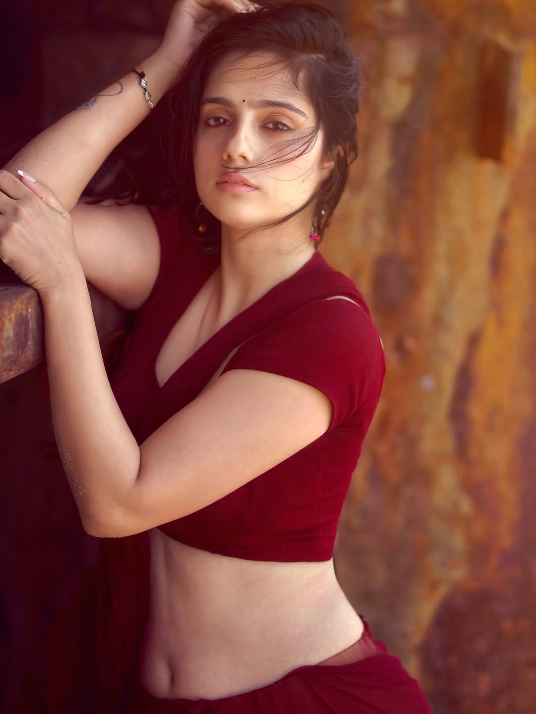 Rose Sardana is seen wearing a deep red outfit with intricate gold embellishments in Photo 1.