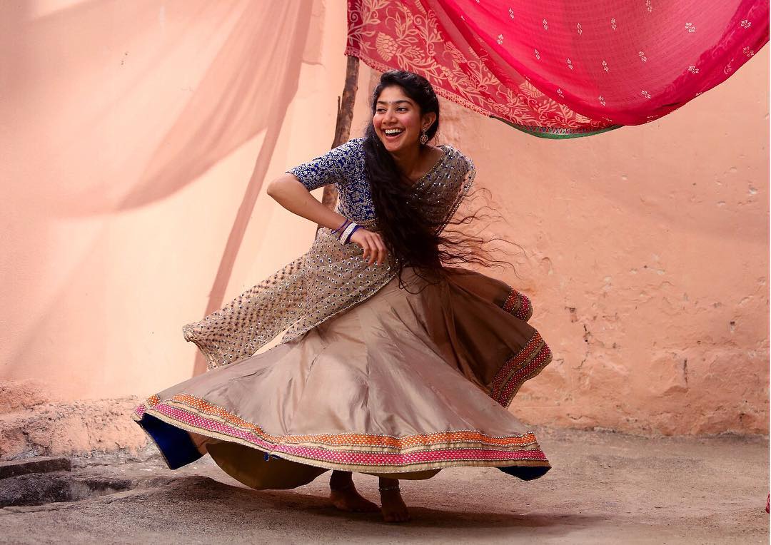 Sai Pallavi in a vibrant coral-red saree on a throne. - Photos & Updates