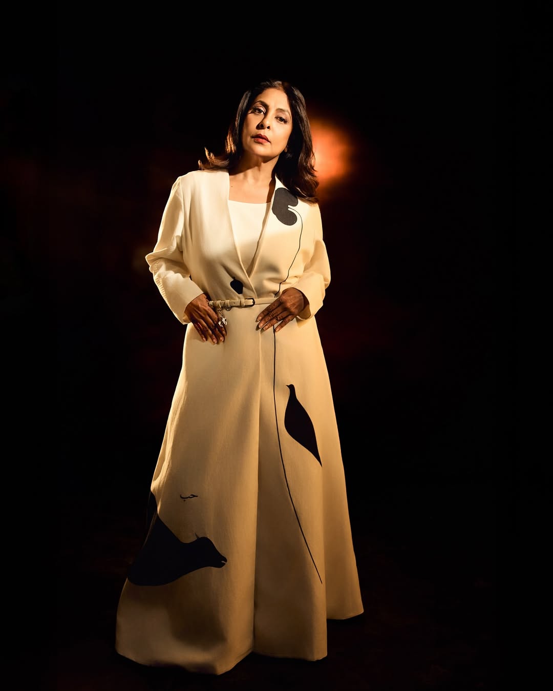 Shefali Shah in a vibrant red garment with gold embroidery, posing intensely for the camera.