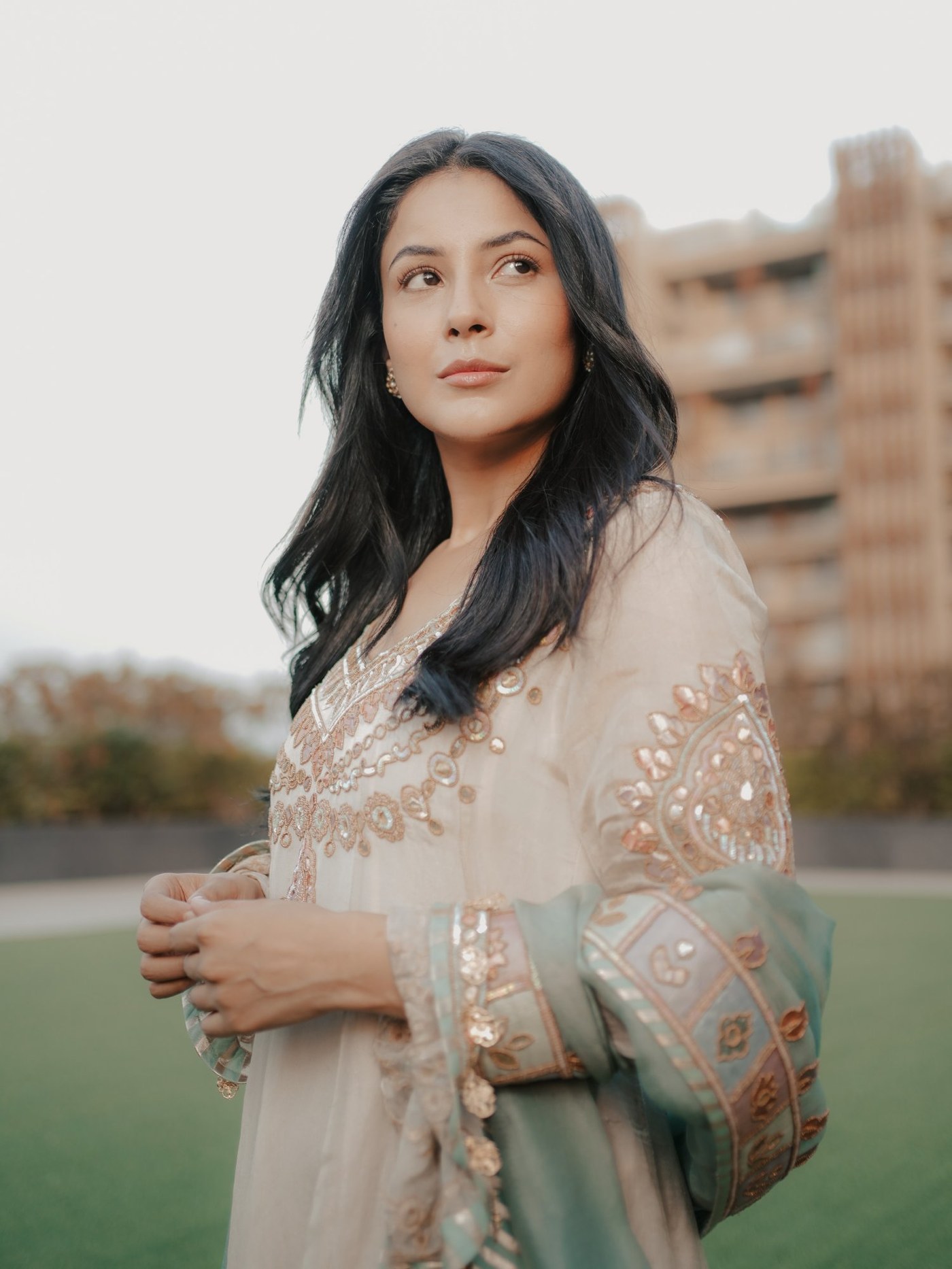 Shehnaaz Gill showcases a graceful, regal embroidered cream Anarkali ensemble with intricate floral detailing.