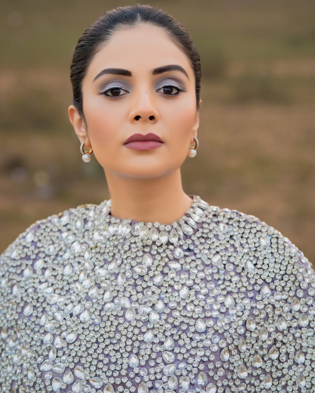 Sreemukhi poses beautifully in a vibrant pink and gold embroidered ensemble.,