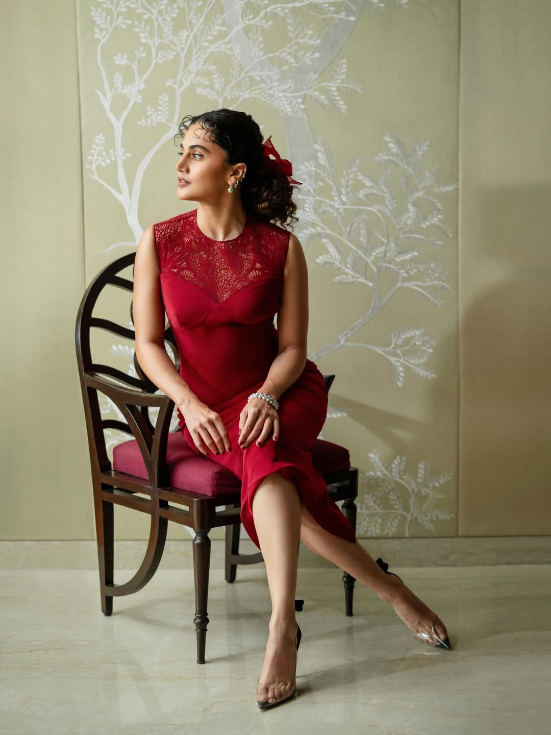Taapsee Pannu poses in a vibrant outfit with striking ethnic jewelry and elegant makeup.