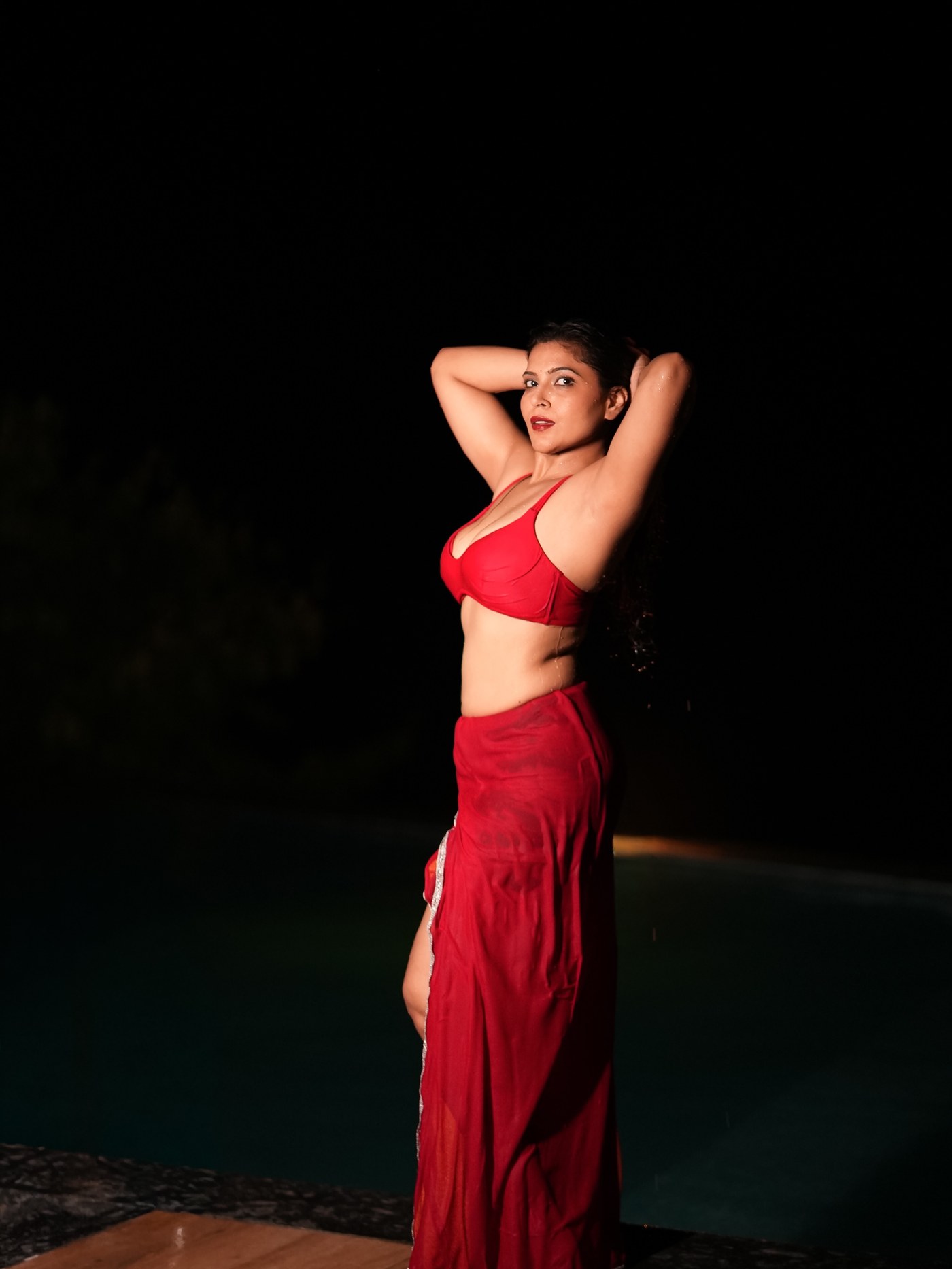 Tanya Chaudhari in a vivid crimson two-piece against rain-soaked night. - Photos & Updates