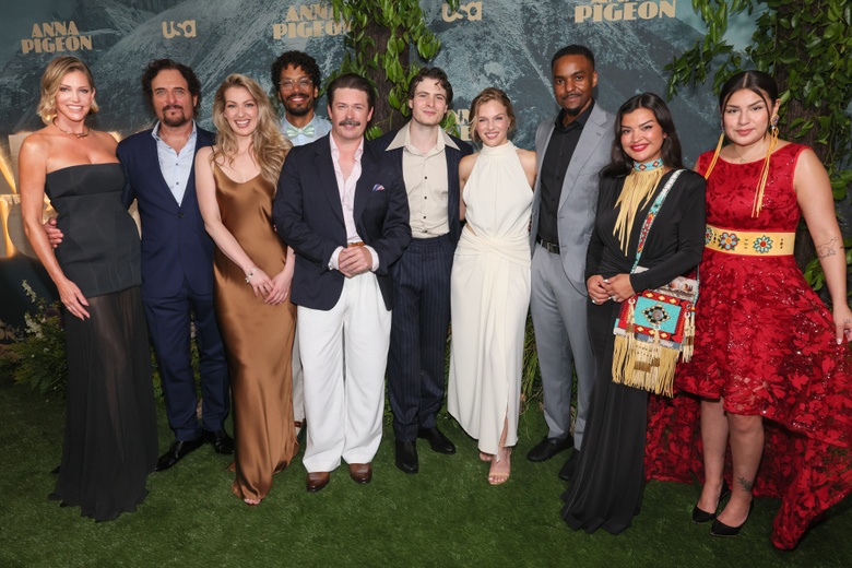 Tricia Helfer attending a premiere, posing gracefully on a red carpet amongst festive lights. - Photos & Updates