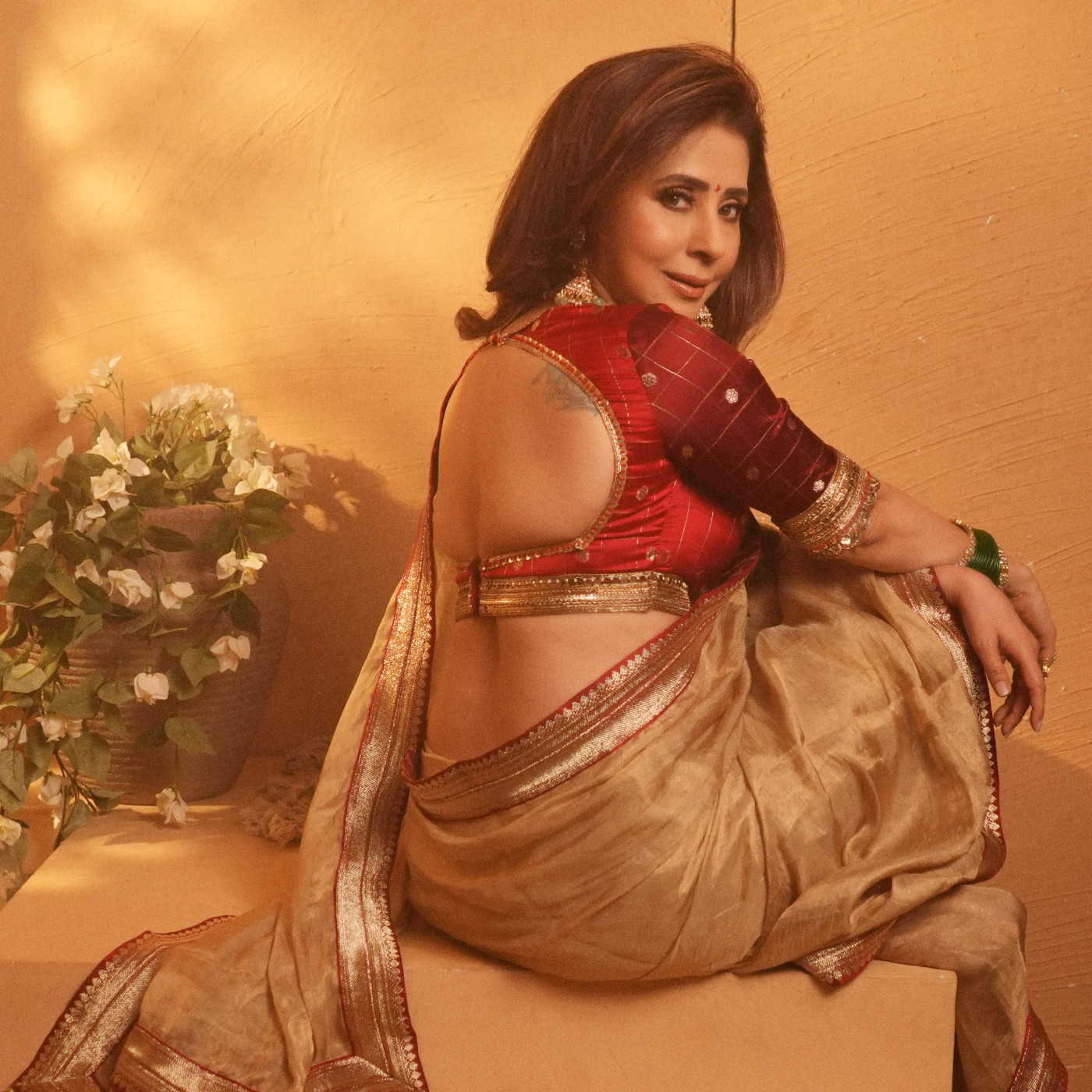 Urmila Matondkar showcases a beige-gold sari paired with a rich red blouse.