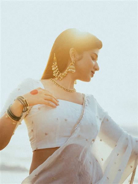 Pragya Nagra striking a pose with an ethereal yellow and orange ensemble backdrop.